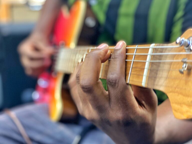 A diverse black African gen x male guitarist musician plays electric guitar skillfully
