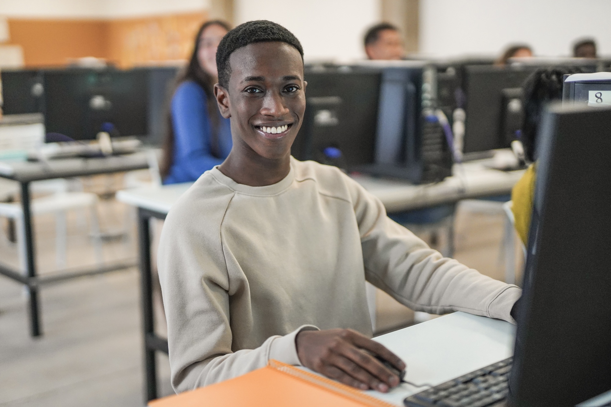 Young african boy smiling on camera inside computer class room Young african boy smiling on camera inside computer class room